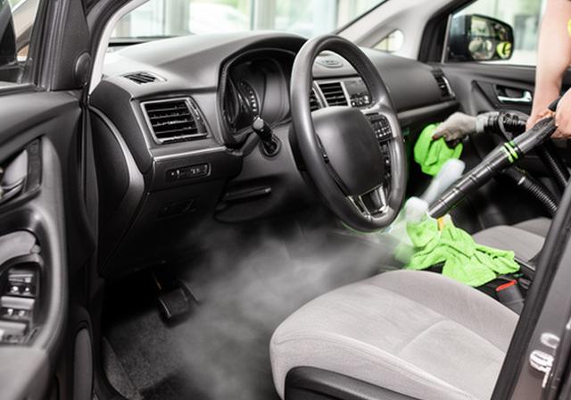 Interior de coche siendo limpiado en profundidad con aspiradora y productos especializados para tapicería en Torrejón de Ardoz